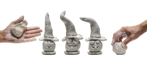 Two unformed lumps of clay and three clay sculptures of wizards.