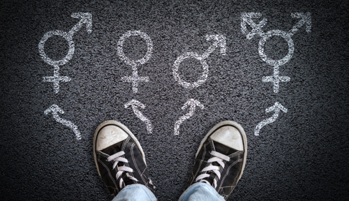 A person stands facing four gender identity symbols.